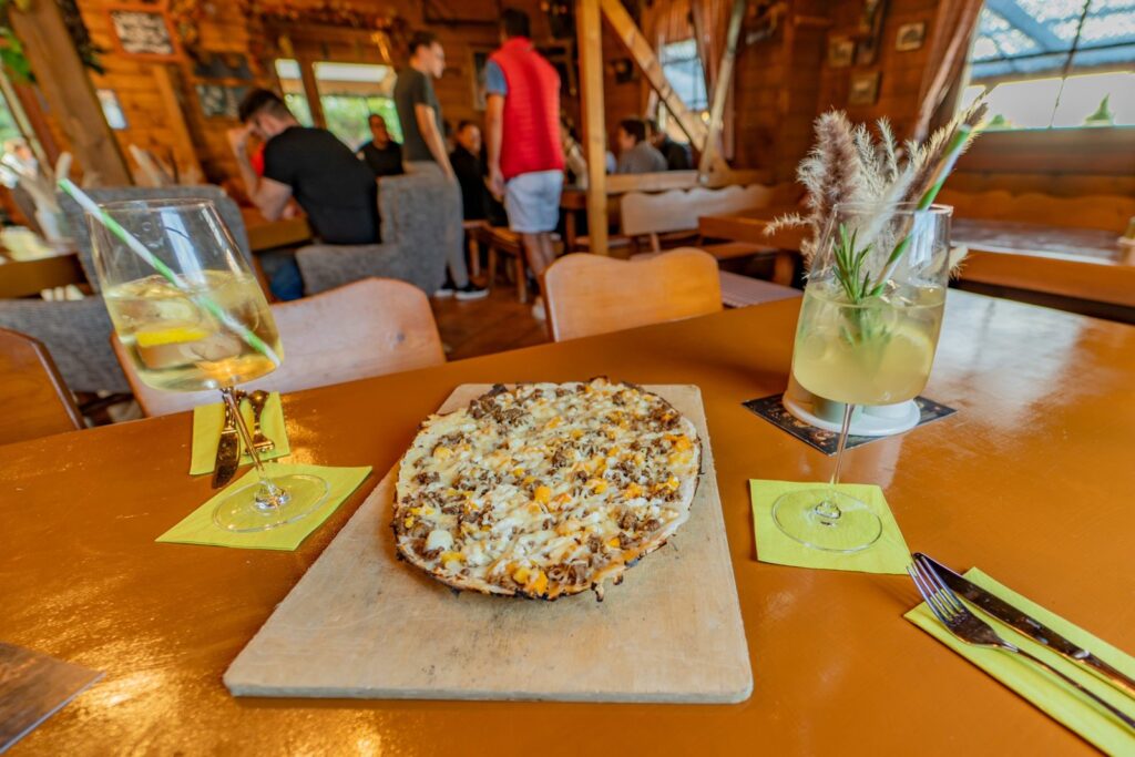 Flammkuchen frisch aus dem Ofen mit Getränk im Gastraum der Flammkuchenhütte Becker, Mehlingen